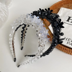 Close-up of floral beaded headbands in black and white with crystal pearl details