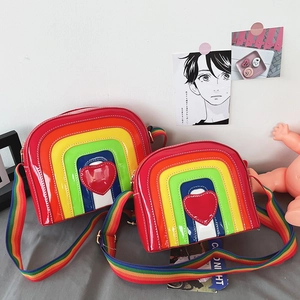Detail of colorful rainbow crossbody bag with heart patch and striped webbing strap