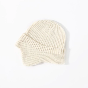 Detailed knit texture of a warm cream-colored ear-protection beanie for winter wear