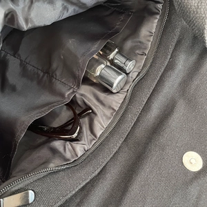 Detail view of the black canvas bag interior with multi-pocket storage and magnetic buckle