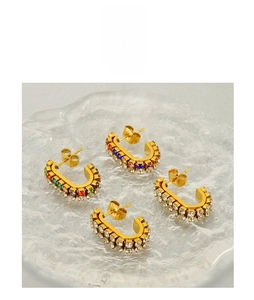 Close-up of gold-plated C-shaped earrings encrusted with colorful cubic zirconia crystals
