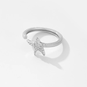 Macro shot of silver starfish ring detail with adjustable band on white background