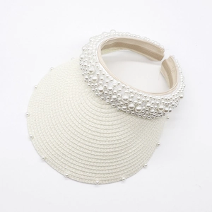 Detail of white woven sun visor hat with faux pearl embellishments on brim and headband