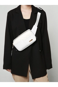 White quilted PU leather waist bag with gold buckle detail shown on model's black blazer
