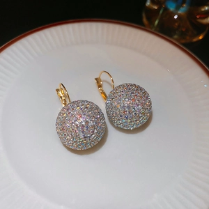 Detail of semi-spherical gold hoop earrings with sparkling rainbow pavé rhinestones
