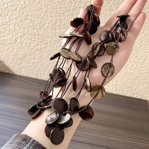 Collana boho con perline irregolari in guscio di cocco e ciondolo a frangia naturale