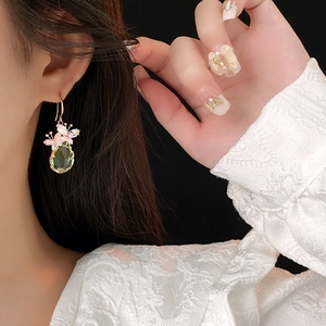Détail de la boucle d'oreille en zircone vert clair en forme de goutte sur mannequin