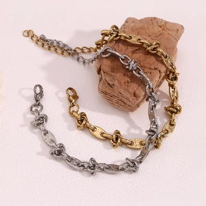 Detailed view of 14K gold coffee bean link bracelet with knot texture on a stone