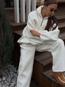 Detail of white oversized half-zip hoodie and wide-leg joggers in a premium fleece set