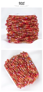Macro view of 18k gold plated red crystal bead chain on white plastic spool