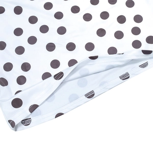 Close-up of double-needle stitching and black polka dot print on summer fabric