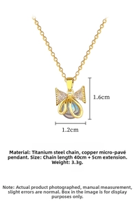 Detailed close-up of golden titanium steel necklace with crystal bow and pearl pendant