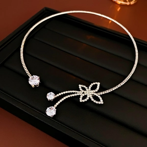 Detailed view of silver choker necklace with diamond butterfly tassels on black tray