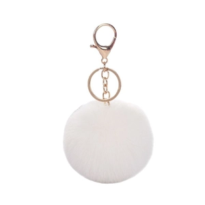 Soft white faux rabbit fur pompom keychain with golden metal clasp on white background