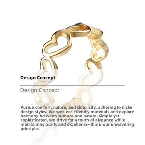 Detail of interlocking golden heart-shaped hollow rings with polished steel finish