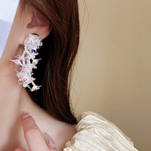 Close-up of floral long tassel earrings with iridescent white beads on a model