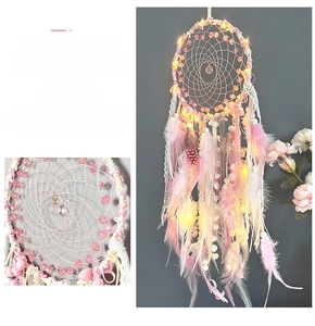 Detail of pink handmade dream catcher with warm LED lights and delicate white feathers