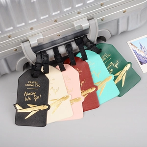 Close-up of colorful PU leather luggage tags with gold plane icons on a silver suitcase