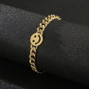 Detailed view of a gold chain style ring with a hollow smiley face metal design