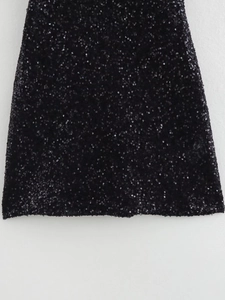 Close-up detail of high-density black sequins on a fitted party dress fabric