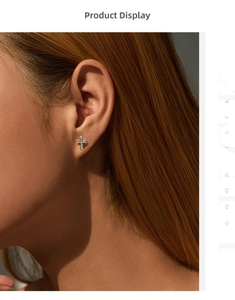 Detail view of a sparkling S925 sterling silver cross earring with micro-pave moissanite