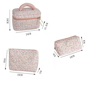 Macro view of floral quilted toiletry bag set with dimension labels and handle details