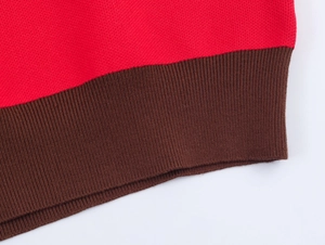 Détail du tissu en maille rouge avec poignet côtelé marron et texture de couture de qualité