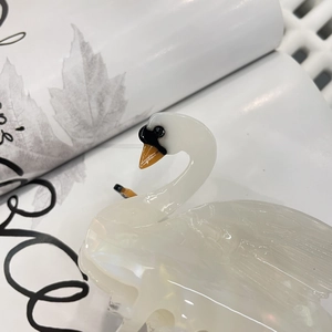 Detailed close-up of a white swan acetate hair claw clip with pearl luster finish