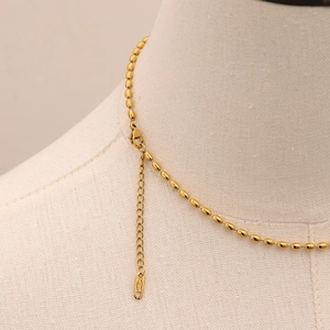 Détail du collier à billes en or 18 carats avec fermoir mousqueton et gravure S.Steel