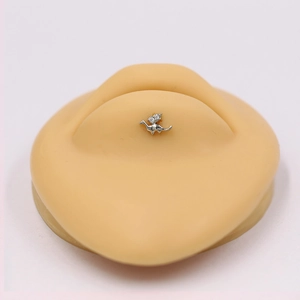 Detail view of silver dinosaur piercing stud featuring clear gems on a model
