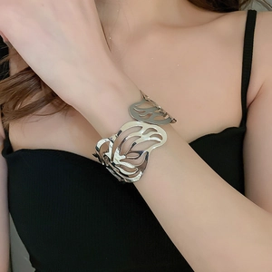 Close-up of a silver hollow butterfly open cuff bracelet worn on the wrist by a model