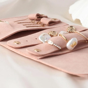 Detail of soft pink microfiber jewelry roll with necklace hooks and ring holders