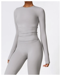 Détail d'un ensemble de yoga gris avec haut froncé à manches longues et legging taille haute