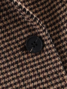 Detailed close-up of brown houndstooth wool fabric and a black four-hole resin button