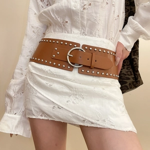 Detail of vintage brown leather wide belt featuring silver metal rivets and round buckle