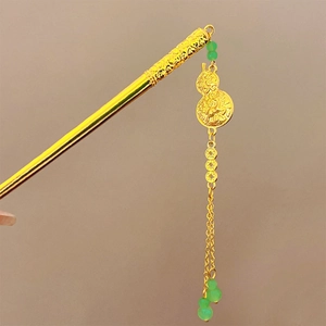 Detail of golden Chinese hairpin with emerald beads and carved gourd pendant design