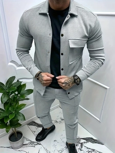 Dettaglio dell'abito da uomo grigio chiaro con micro-tessitura plissettata e maglia