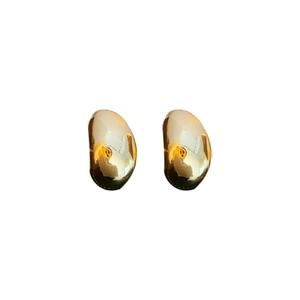 Minimalist golden bean-shaped stud earrings in polished metal on a white background