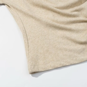 Detailed view of beige knit fabric texture and side seam stitching of the vacation set