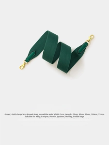 Detail of green 5cm wide woven bag strap with genuine leather ends and gold metal hooks