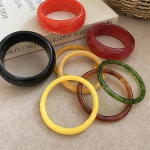 Close-up of colorful resin bangles with marble texture on an artistic retro background
