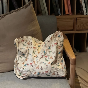 Detail of canvas tote bag featuring colorful hand-drawn dog prints and a side brand label