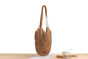 Close-up of V-shaped handwoven texture and premium leather strap on the brown tote bag