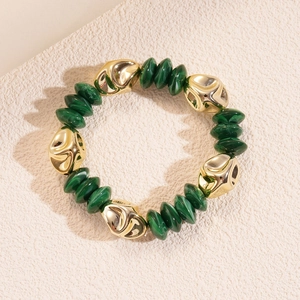 Close-up of green malachite texture beads and irregular gold metal links on a bracelet