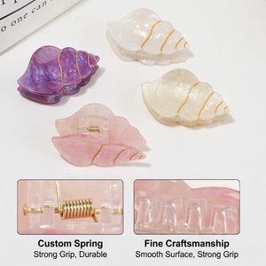 Pearlescent seashell hair claws with gold lines in purple, pink, and white tones
