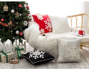 Detailed close-up of embroidered snowflake patterns on festive Christmas cushion covers