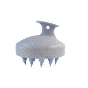 Detail of light blue wheat straw scalp massager brush with ergonomic handle and soft bristles