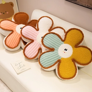 Soft sherpa flower cushions with cute smile faces on a white sofa for home decor.