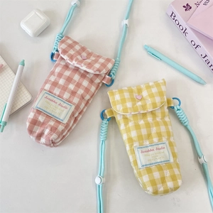 Close-up of quilted crossbody phone bags in pink and yellow with adjustable blue straps