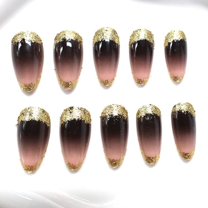 Almond press-on nails set with black and pink gradient design and gold glitter accents
